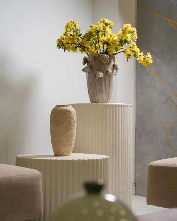 Colonne cannelée, vase et fleurs jaunes